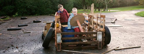 two boys in a wooden toy car