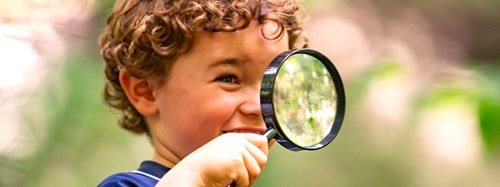 boy looking through a magnifying glass