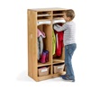 A boy is hanging his jacket into solid maple wood preschool cubbies with baskets