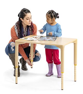 a child playing at an adjustable table