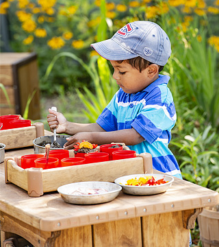 A child playing with an Outlast Classic Kitchen counter