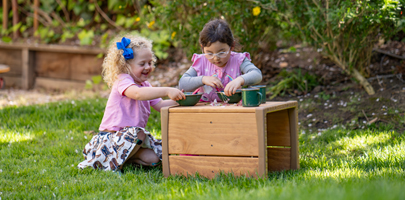 Two children playing with Outlast Cube table