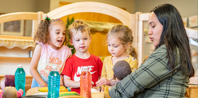 Children and teacher in dramatic play corner
