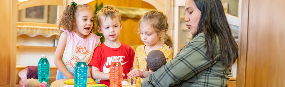 Children and teacher in dramatic play corner