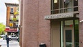 Exterior of Maple Street School building with brick facade, large windows, and a street view.