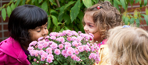 two girls smelling flowers