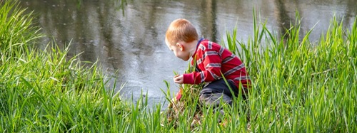 boy playing by a stream