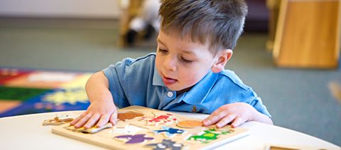 boy putting together a puzzle