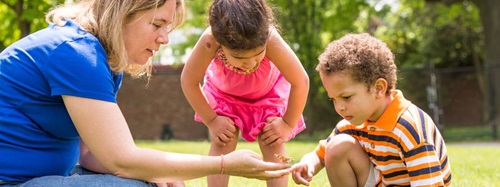 two children looking at a butterfly