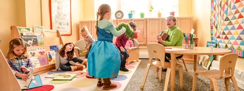 teacher playing guitar to children