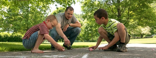 children drawing with chalk on blacktop