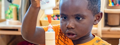 child glueing pieces together