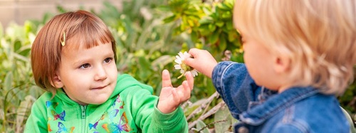 two children holding a flower