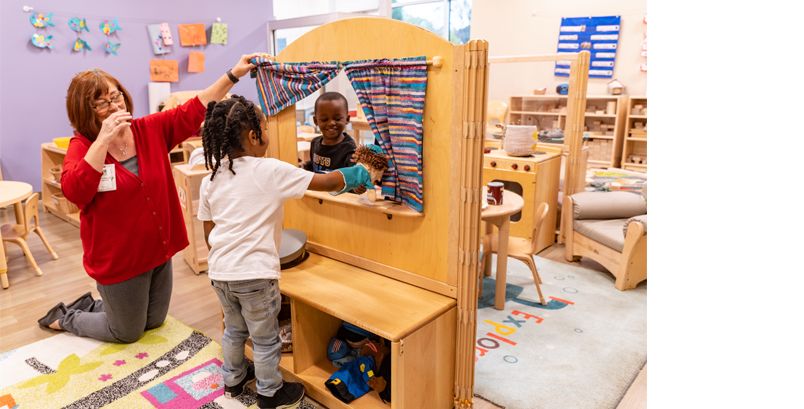 Preschool kids and teacher playing with puppets