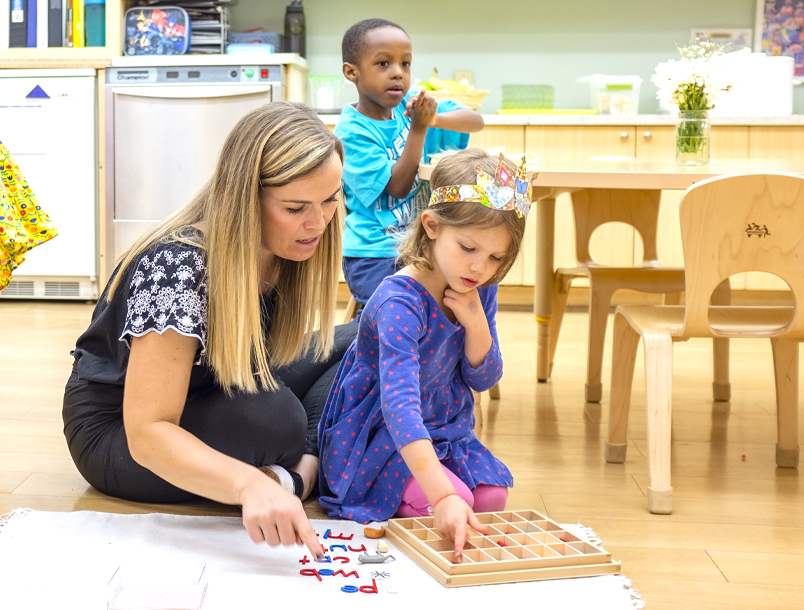 A teacher and a child teaching in a Montessori classroom