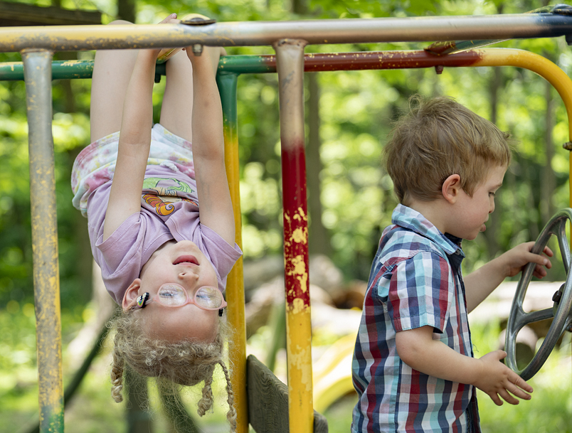 A child hanging upside down from bars