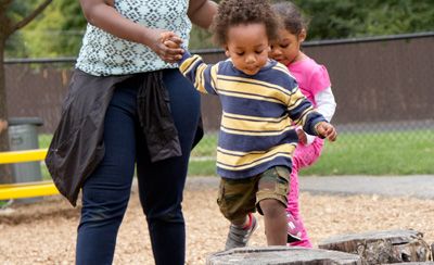 two children balancing on stumps