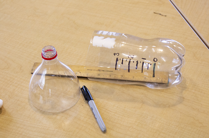 20 oz soda bottle cut apart, ruler, and sharpie