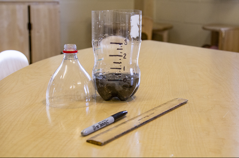 Cut soda bottle, inches marked on the side with a sharpie