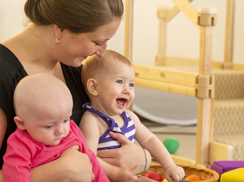 An adult holds two infants