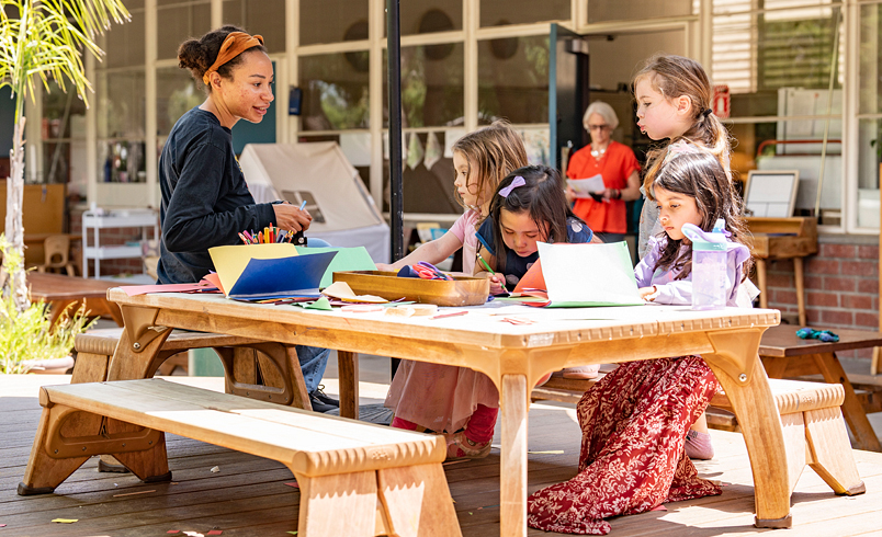 teacher with preschool kids doing art project outdoors