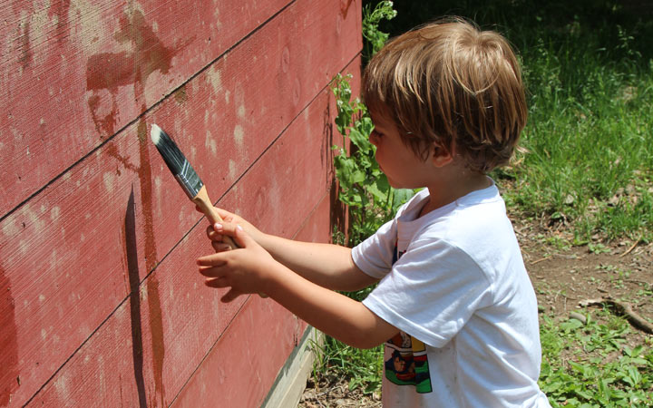child painting with water on the side of a building