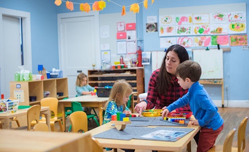 Teacher with two children in an early years classroom