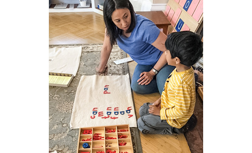 Educator teaching a student to read with plastic letters