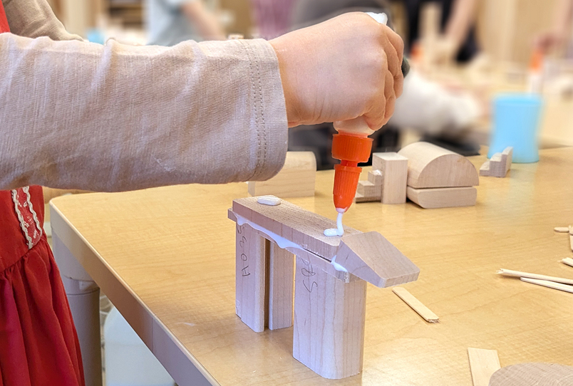 A child gluing wooden pieces