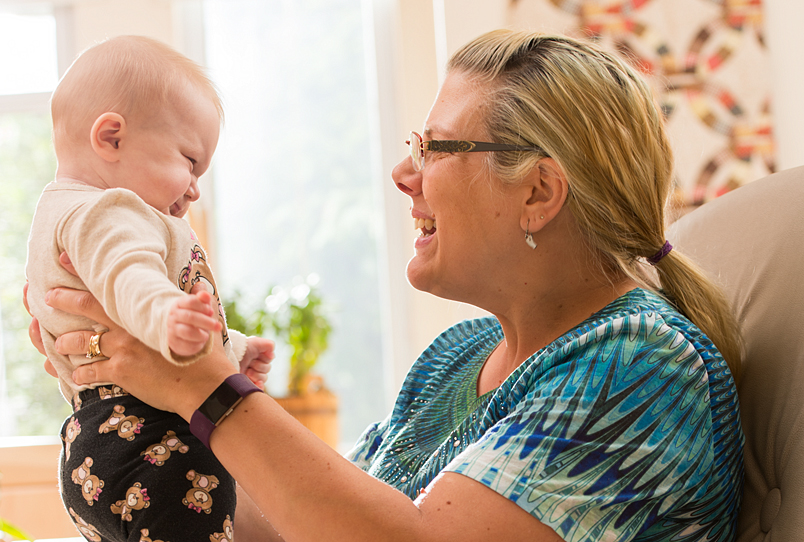 Teacher holding a baby face to face