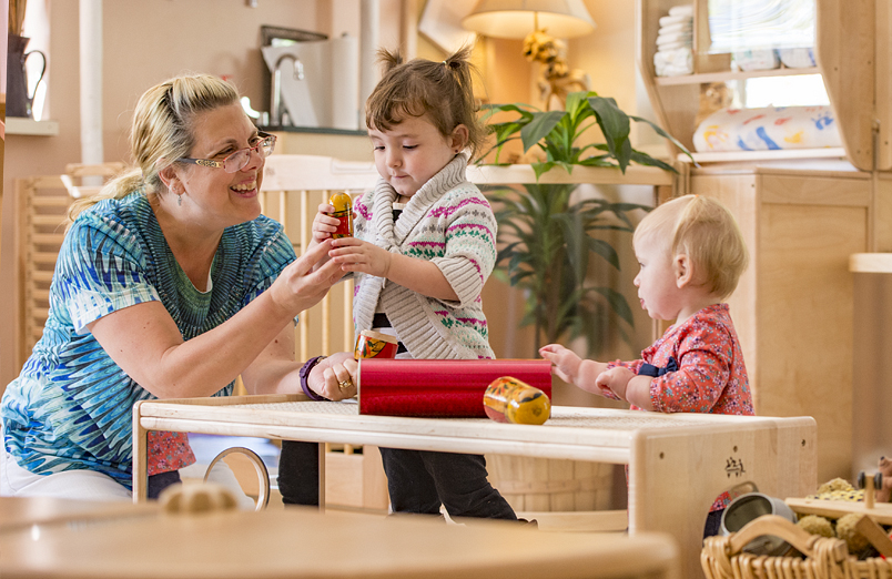 teacher playing with little girls in a toddler calssroom