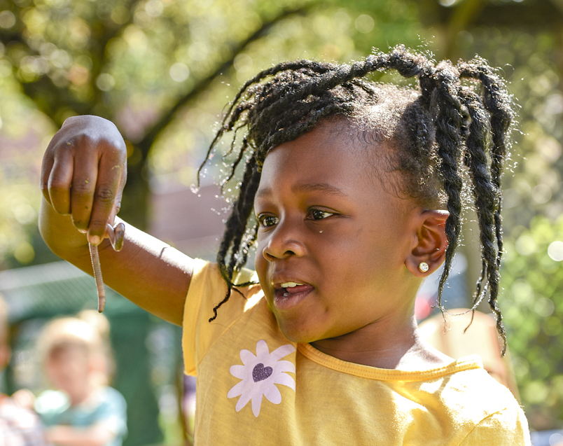 A child looking at a worm