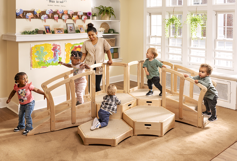 Children clambering over a Large Toddler Climber with a teacher watching