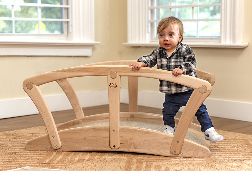 A child walking up and over the Toddler Climber Bridge