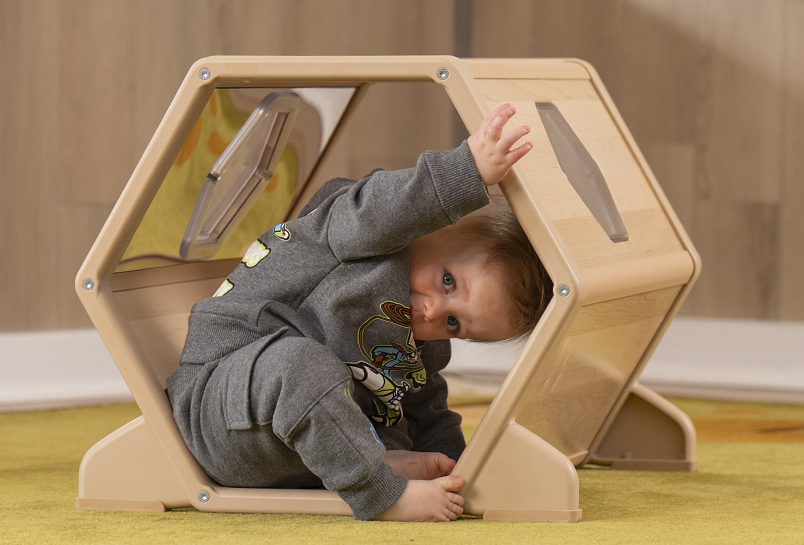 A child pushing against the inside of the Toddler Climber Tunnel