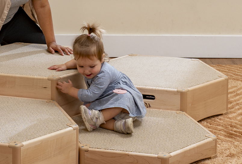 A child clambering on the Toddler Climber Beehive Set