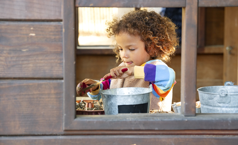 A child playing in a playhouse outdoor