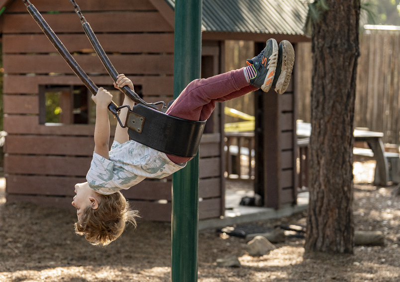 A child swinging outside