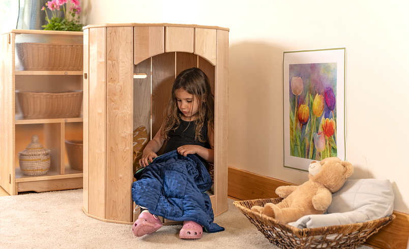 A child sitting in a Community Playthings retreat