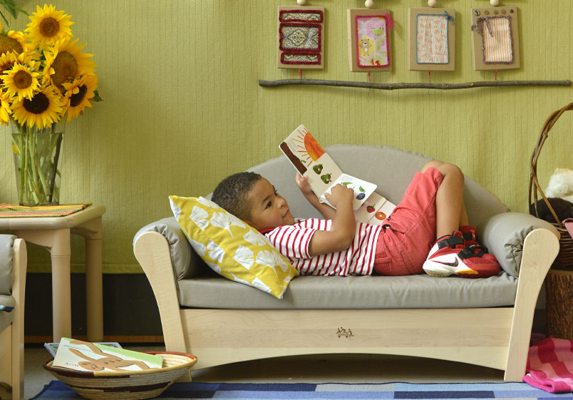 A child lying on a Community Playthings Sofa