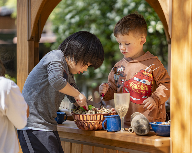 Two children playing in the Outlast Playhouse