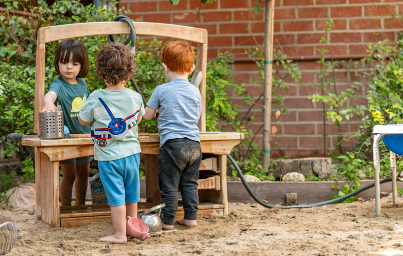 Toddlers playing with an Outlast Mud Kitchen