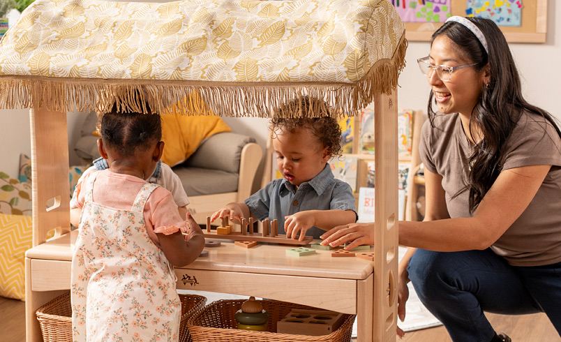 Teacher guiding toddler play 
