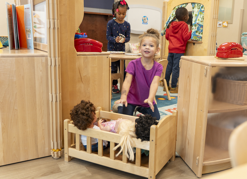 A child playing with dolls