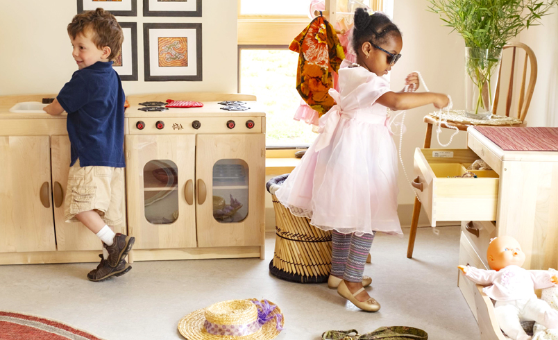 Two children playing with Woodcrest Kitchen Play House set
