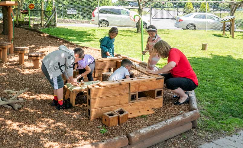 Children and teacher constructing a structure out of Outlast Blocks