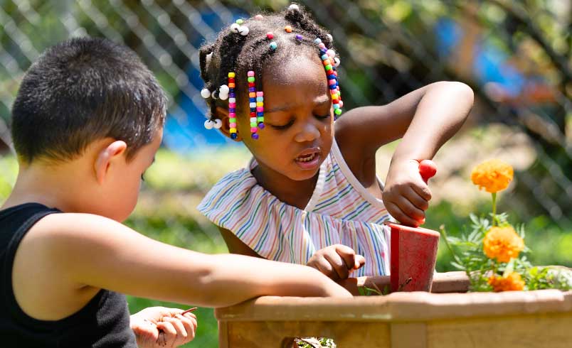 Children planting flowers in Outlast Risers