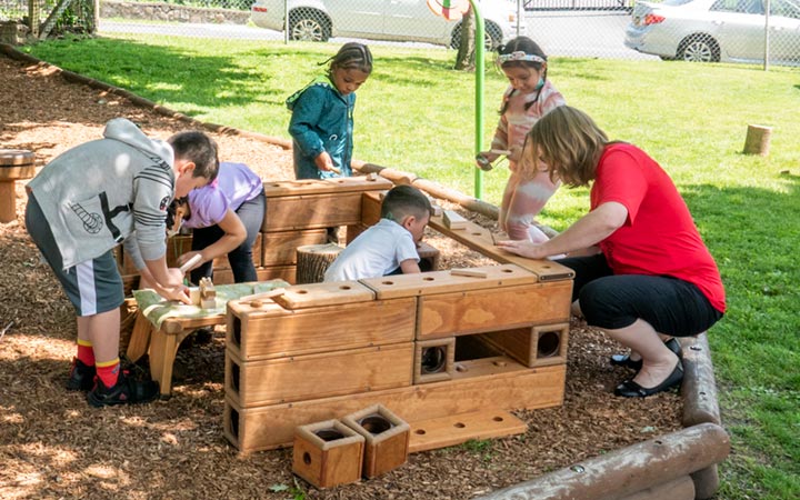 Teacher and a group of children working together to build large structure with Outlast Blocks