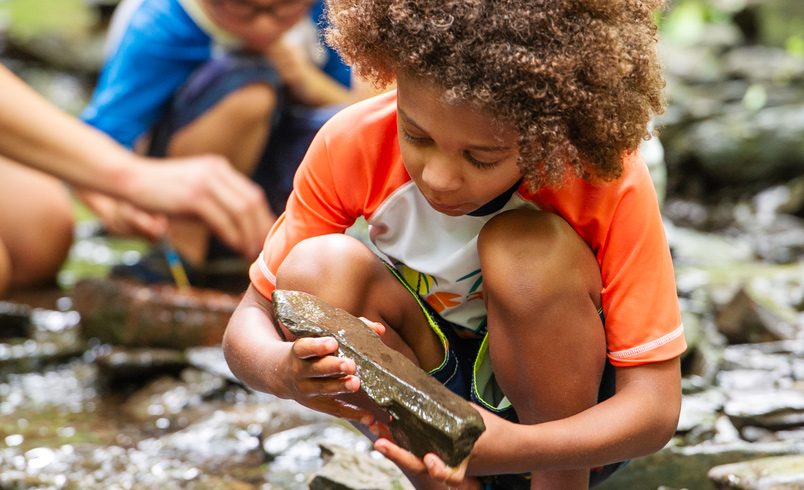 Child examining stone