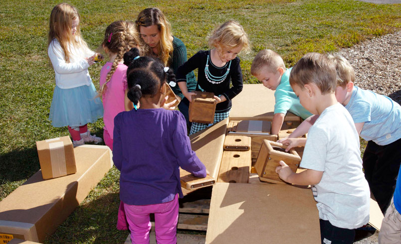 Children and staff opening box of Outlast blocks